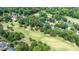 An aerial view shows a golf course community with lush green trees and well maintained lawns at 204 Muirfield Ln, Clayton, NC 27527