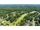 An aerial view features a golf course community with trees, ponds, and single Gathering homes at 204 Muirfield Ln, Clayton, NC 27527