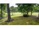 Backyard has mature trees and lawn that leads to a golf course at 204 Muirfield Ln, Clayton, NC 27527