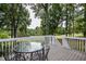 A peaceful backyard deck and a glass table with chairs overlooking lush greenery at 204 Muirfield Ln, Clayton, NC 27527