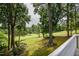 Expansive backyard with mature trees and lush green grass extending to the golf course beyond at 204 Muirfield Ln, Clayton, NC 27527