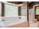 Spa-like bathroom with a jetted tub and a separate tiled shower at 204 Muirfield Ln, Clayton, NC 27527