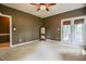 Bright primary bedroom with neutral carpet, a full length mirror, and access to the outdoor deck at 204 Muirfield Ln, Clayton, NC 27527