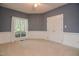 Bedroom features a window with curtains, light carpet and white trim and neutral walls at 204 Muirfield Ln, Clayton, NC 27527