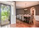 Elegant dining room with hardwood floors, a modern chandelier, and a view to the landscaped front porch at 204 Muirfield Ln, Clayton, NC 27527