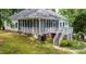 Expansive exterior showcasing a screened porch and deck overlooking the lush, green backyard at 204 Muirfield Ln, Clayton, NC 27527