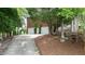 Brick house with a three car garage nestled among mature trees and landscaping at 204 Muirfield Ln, Clayton, NC 27527