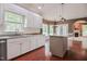 Bright kitchen featuring white cabinets, granite countertops, stainless steel appliances and hardwood floors at 204 Muirfield Ln, Clayton, NC 27527
