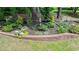 Manicured landscaping highlighting a stone-bordered flower bed with unique garden ornaments at 204 Muirfield Ln, Clayton, NC 27527