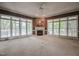 Spacious living room with a fireplace, large windows, and a ceiling fan for a cozy atmosphere at 204 Muirfield Ln, Clayton, NC 27527