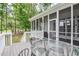 Outdoor screened porch and glass table with chairs overlooking lush greenery at 204 Muirfield Ln, Clayton, NC 27527