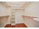 Walk-in closet with hardwood floors and custom built-in shelves and racks for ample storage at 204 Muirfield Ln, Clayton, NC 27527