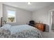 This light bedroom offers gray walls, neutral carpet, and a blue floral comforter at 2070 Great Ridge Pkwy, Chapel Hill, NC 27516