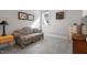 Bedroom with patterned couch, neutral walls, gray carpeting, and natural light through the window at 2070 Great Ridge Pkwy, Chapel Hill, NC 27516