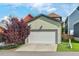 View of the attached two-car garage with a concrete driveway and mature tree at 2070 Great Ridge Pkwy, Chapel Hill, NC 27516