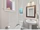 Neat powder room featuring a pedestal sink, toilet, and decorative mirror at 2070 Great Ridge Pkwy, Chapel Hill, NC 27516