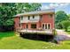 Two-story brick home with a large backyard featuring a deck, patio and mature trees at 2109 W Marilyn Cir, Cary, NC 27513
