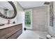 Modern bathroom showcasing a walk-in shower, decorative mirror, and contemporary vanity with stone countertop at 2109 W Marilyn Cir, Cary, NC 27513