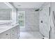 Beautiful bathroom featuring double vanity, marble tile and frameless glass shower at 2109 W Marilyn Cir, Cary, NC 27513