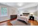 Relaxing bedroom featuring hardwood floors, a stylish rug, and ample natural light at 2109 W Marilyn Cir, Cary, NC 27513