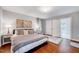 Bright bedroom features hardwood floors, neutral walls, decorative art, and ensuite bathroom at 2109 W Marilyn Cir, Cary, NC 27513