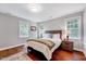 Comfortable bedroom with hardwood floors, a plush bed, and serene natural light from multiple windows at 2109 W Marilyn Cir, Cary, NC 27513