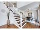 Bright entryway showcasing a modern staircase with wooden treads and metal railings at 2109 W Marilyn Cir, Cary, NC 27513