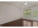 This bedroom features hardwood floors, a ceiling fan, and a window with natural light and a door to the outside at 220 Mount Evans Dr, Durham, NC 27705