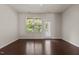 This bedroom features hardwood floors, a ceiling fan, and a window with natural light and a door to the outside at 220 Mount Evans Dr, Durham, NC 27705