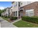 Well-maintained townhome features brick accents, clean sidewalks, and verdant lawns enhancing its curb appeal at 220 Mount Evans Dr, Durham, NC 27705