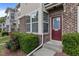 Charming townhome exterior highlighting brick detail, a pop of color from the front door, and manicured greenery at 220 Mount Evans Dr, Durham, NC 27705