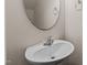 Half bathroom with a sleek, round mirror, and a modern pedestal sink featuring chrome fixtures at 220 Mount Evans Dr, Durham, NC 27705