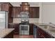 Well-equipped kitchen featuring stainless steel appliances, dark cabinets, and granite countertops at 220 Mount Evans Dr, Durham, NC 27705
