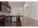 This open kitchen features stainless steel appliances, granite counters, and a tiled backsplash at 220 Mount Evans Dr, Durham, NC 27705