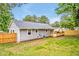 View of the backyard with a gray home, wooden deck, green grass, and wood fence at 2200 Wyman Pl, Durham, NC 27707