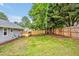 Spacious backyard with a wooden fence, green lawn, and access to a wooden deck at 2200 Wyman Pl, Durham, NC 27707