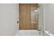 Updated bathroom featuring a tub with stylish wood accent wall and glass door at 2200 Wyman Pl, Durham, NC 27707