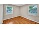 Bedroom featuring hardwood floors, base trim, and two windows at 2200 Wyman Pl, Durham, NC 27707
