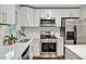 Bright modern kitchen features white cabinets, stainless steel appliances, and white quartz countertops at 2200 Wyman Pl, Durham, NC 27707