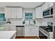 Modern eat-in kitchen featuring white cabinets, stainless steel appliances, and white quartz countertops at 2200 Wyman Pl, Durham, NC 27707