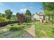 Landscaped backyard featuring a brick walkway and verdant garden beds with various plants and greenery at 231 Heather Bluffs Dr, Garner, NC 27529