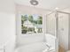 Elegant bathroom with a glass enclosed shower and a garden tub below the window at 231 Heather Bluffs Dr, Garner, NC 27529