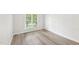Bright bedroom features wood-look floors, large window and baseboard trim at 231 Heather Bluffs Dr, Garner, NC 27529