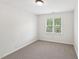 This bedroom has a neutral-colored carpet and neutral-colored walls and trim at 231 Heather Bluffs Dr, Garner, NC 27529