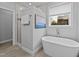 Bright bathroom featuring a soaking tub, walk-in shower, and tile floors at 2500 Plowridge Rd, Fuquay Varina, NC 27526
