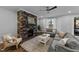 Comfortable living room with a stone fireplace, ceiling fan and lots of natural light at 2500 Plowridge Rd, Fuquay Varina, NC 27526
