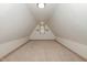 Finished attic space with neutral carpet and a charming window at 2714 Wedgedale Ave, Durham, NC 27703