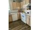 Kitchen featuring white appliances, light wood cabinets, and wood-look flooring at 3000 Centennial Woods Dr # 302, Raleigh, NC 27603