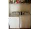 Washer and dryer units in dedicated laundry area with shelving at 3000 Centennial Woods Dr # 302, Raleigh, NC 27603