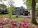 Lush backyard with a wooden deck, landscaping, a rock creek bed, and mature trees providing shade and privacy at 306 Roebling Ln, Cary, NC 27513
